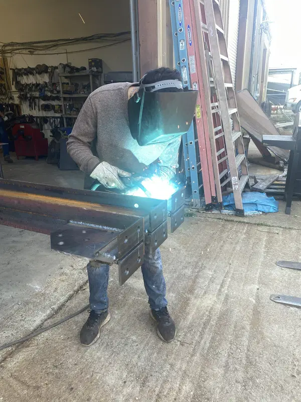Welder completing a custom steel fabrication project in the shop